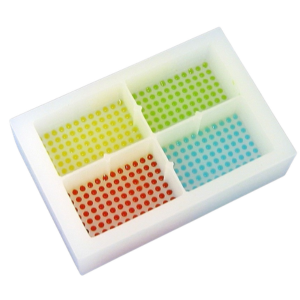 White plastic tray with four square compartments, each containing a grid of colored dots (yellow, green, red, blue).